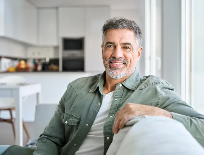 Smiling man in his 50s relaxing at home