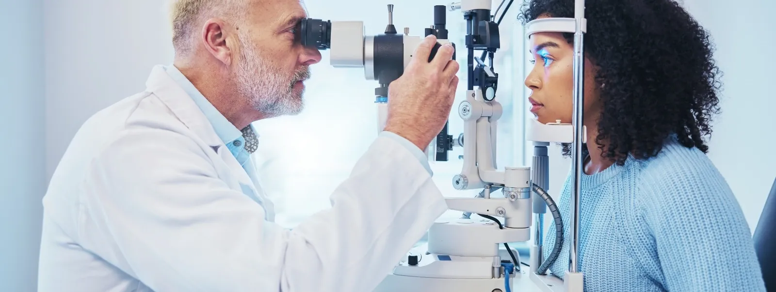 Eye doctor examining a patient with a slit lamp